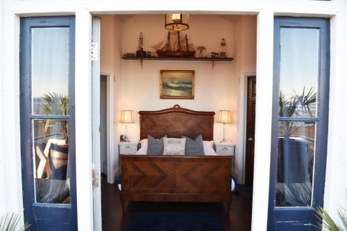 - une chambre avec un lit et 2 fenêtres dans l'établissement The West Usk Lighthouse Lightkeepers Lodge, à Newport