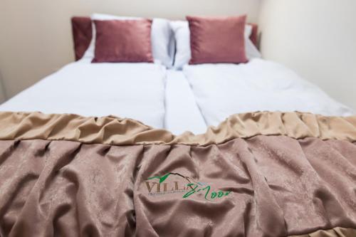 a bed with a brown blanket on top of it at Villa Noor in Sarajevo