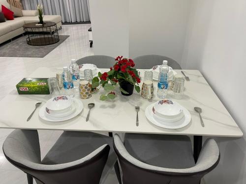 Eaton Residences KLCC by Luna في كوالالمبور: طاولة بيضاء عليها صحون و ورد