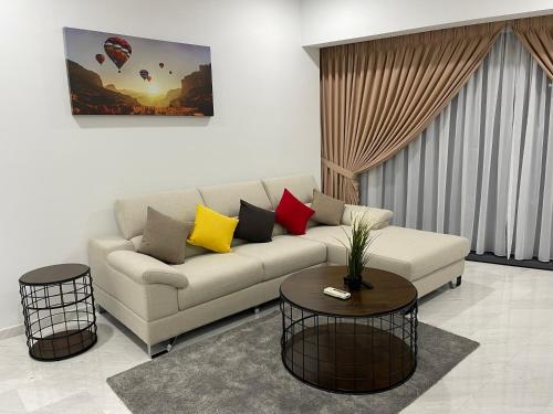 een woonkamer met een bank en 2 tafels bij Eaton Residences KLCC by Luna in Kuala Lumpur
