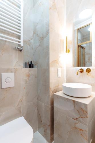 a bathroom with a white toilet and a sink at Warsaw Story - LoftAffair Collection in Warsaw