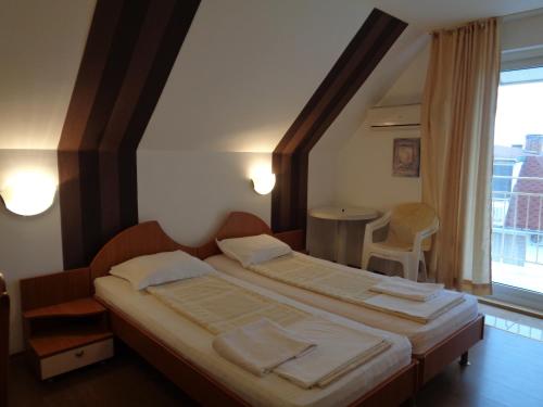 a bedroom with two beds and a large window at Стаи за гости" Герови" in Nesebar