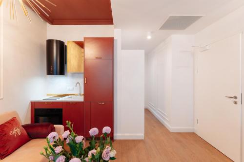 a kitchen and a living room with a red cabinet at Warsaw Story - LoftAffair Collection in Warsaw