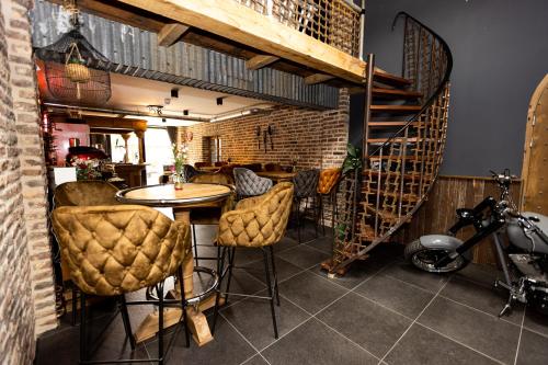 a room with a table and chairs and a staircase at VET - Bed & Breakfast in Beek