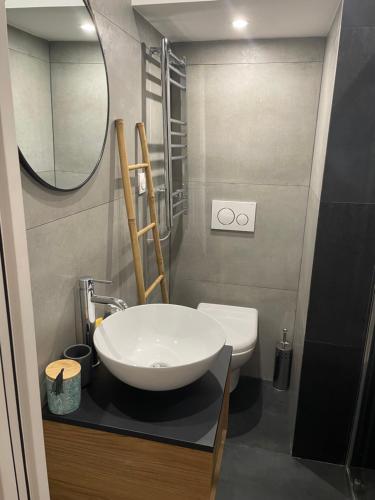 een badkamer met een witte wastafel en een spiegel bij La Bibiane Beaulieu sur mer !!! in Beaulieu-sur-Mer