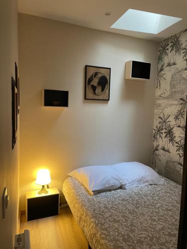 - une chambre avec un lit avec une lampe et un mur dans l'établissement La Bibiane Beaulieu sur mer !!!, à Beaulieu-sur-Mer