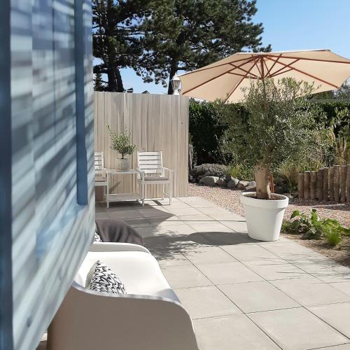 a patio with two chairs and an umbrella at Casa Pueblo Viejo in Ouddorp