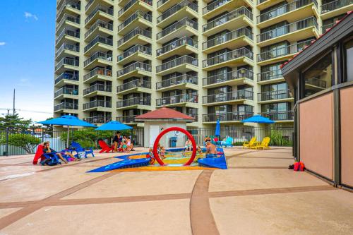 a group of people playing on a playground in front of a building at Sea Watcher in Ocean City