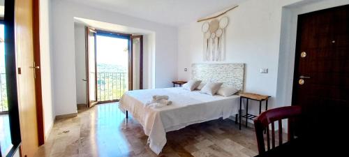 a white bedroom with a bed and a window at O' Stiavucco B&B in Corleto Monforte