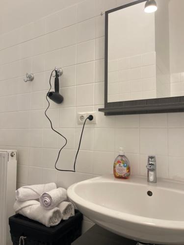 ein Badezimmer mit einem Waschbecken, einem Spiegel und Handtüchern in der Unterkunft Gesamte Unterkunft im Zentrum von Wien Top 27 in Wien
