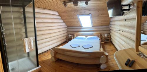 a bedroom with a bed in a wooden room at Gostynna sadyba Kit Bayun in Teterivka