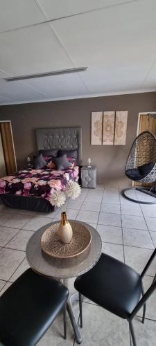 a room with a table and two chairs and a bed at Funky Dot Sleeping Spot in Kempton Park