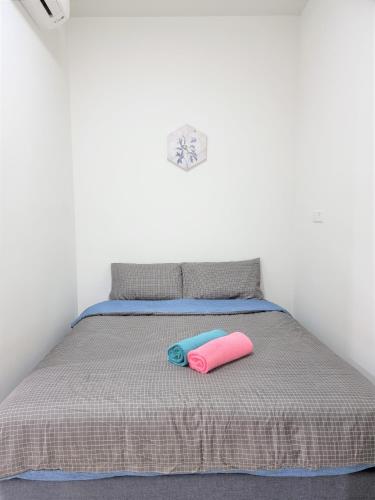 a bed with two pink and blue pillows on it at Studio at The Ridge KL East J in Kuala Lumpur