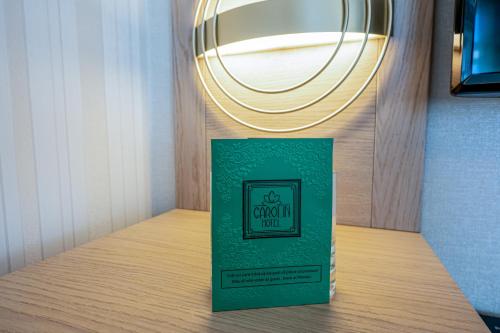 a green box sitting on a table with a light at Hotel Carolin in Călimăneşti