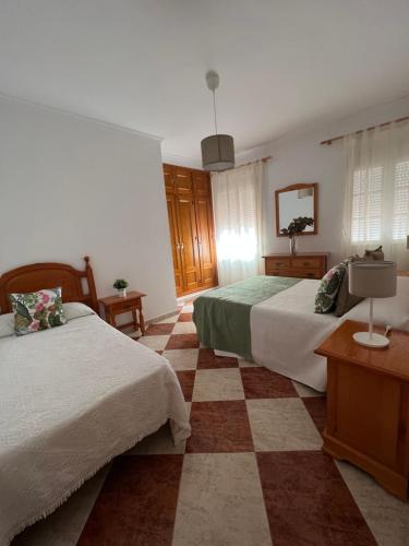 - une chambre avec 2 lits et une télévision dans l'établissement Casas PARAJE NATURAL, à Zahara de la Sierra