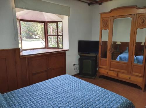 1 dormitorio con 1 cama, vestidor y ventana en Quinta Maria en Lobos