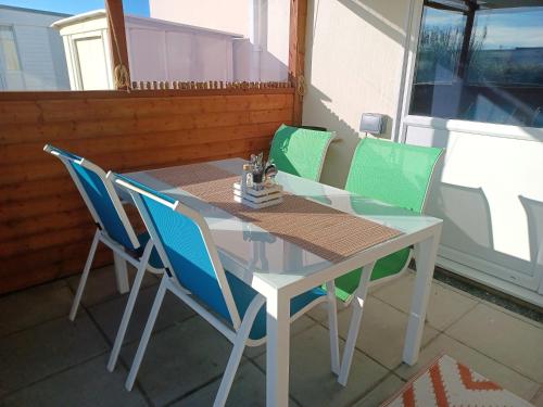 a table and chairs on a patio with a window at 2-bedroom Holiday Home With Great Outdoor Space in Kidwelly
