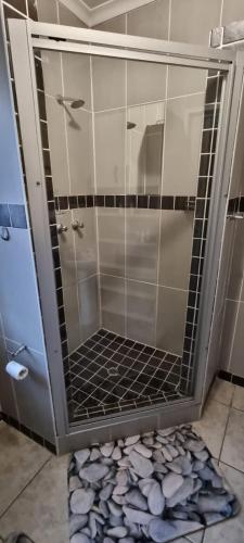a shower with a glass door in a bathroom at Funky Dot Sleeping Spot in Kempton Park