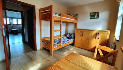 Zimmer mit 2 Etagenbetten und einem Tisch in der Unterkunft APARTAMENTY TR 11 Apartament nr 6 in Olsztyn