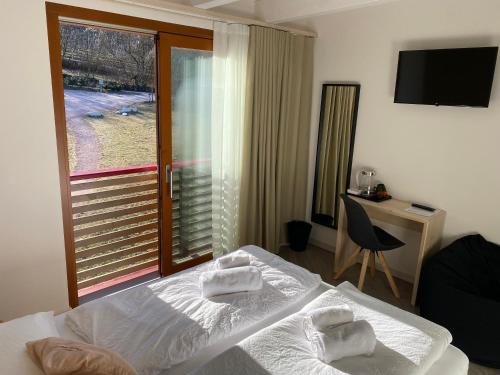 a bedroom with a bed and a desk and a window at Agritur Verderame in Trento