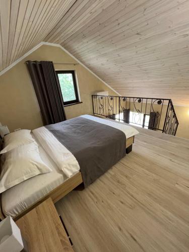 un grande letto in una camera con soffitto in legno di Gostynna sadyba Kit Bayun a Teterivka