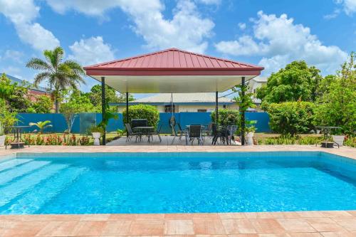 a swimming pool with a gazebo and a house at Traum House in Saint Augustine