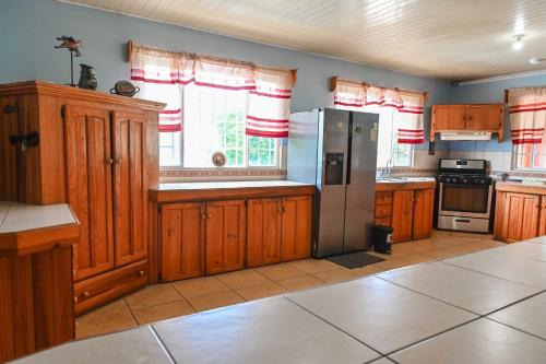 a kitchen with wooden cabinets and a stainless steel refrigerator at Traum House in Saint Augustine