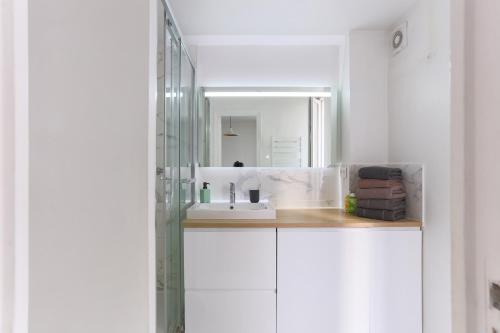 une salle de bain avec un lavabo et un miroir dans l'établissement Eiffel Tower Royal Apartment, à Paris