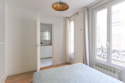 1 dormitorio con cama y ventana grande en Eiffel Tower Royal Apartment, en París