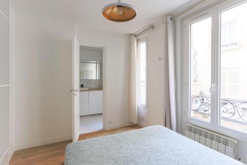 une chambre avec un lit et une grande fenêtre dans l'établissement Eiffel Tower Royal Apartment, à Paris