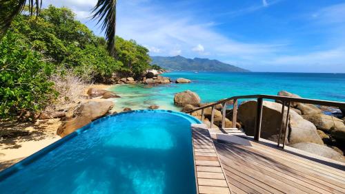 a plunge pool on a beach next to the ocean at Marquise & Infinity villas in Glacis