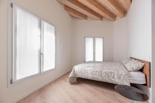 a bedroom with a bed and a large window at Palazzo '900 Design Flats - L'Orologiaio in Padova