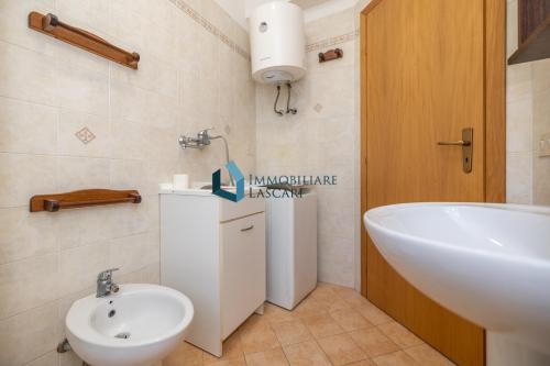 łazienka z umywalką, toaletą i wanną w obiekcie Villa Siragusa con piscina condominiale w mieście Campofelice di Roccella