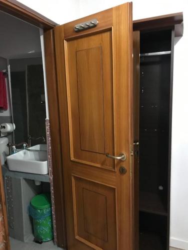 una puerta de madera en un baño con lavabo en Brutarilor Guest House, en Cluj-Napoca