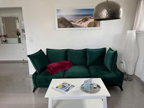 a green couch in a living room with a table at Ferien-Whg Möwe nähe Steinhuder Meer in Hagenburg