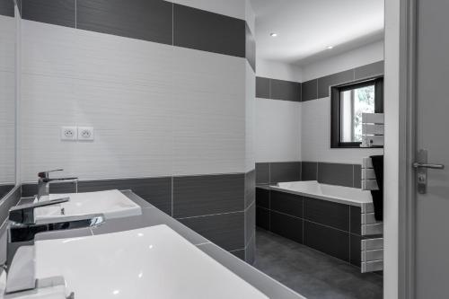 łazienka z 2 umywalkami i wanną w obiekcie VILLA KOÏ CASTELLET*PISCINE*SPA*SALLE DE SPORT*CINÉMA* w mieście Cuges-les-Pins