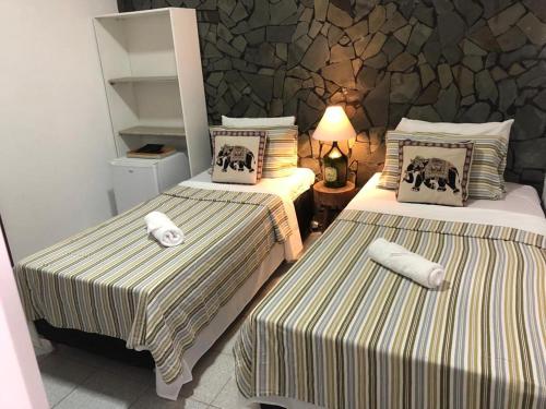 Habitación de hotel con 2 camas y toallas. en Pousada Hosp Cantinho de Minas en Cabo Frío