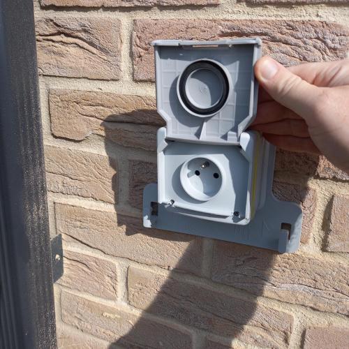 a person holding a security camera on a brick wall at Fraisier, hotel artres - valenciennes in Quérénaing
