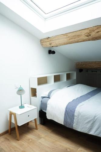 une chambre avec un lit et un plafond en bois dans l'établissement La Grange 1832 - A 10 mins d'Aubenas, à Saint-Étienne-de-Boulogne