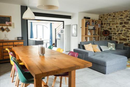 uma sala de estar com uma mesa de madeira e um sofá em La Grange 1832 - A 10 mins d'Aubenas em Saint-Étienne-de-Boulogne