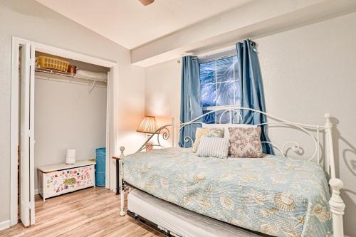 een slaapkamer met een bed met blauwe gordijnen en een raam bij Home with enclosed yard, fire pit, WiFi, W/D, & AC - great location in Villano Beach
