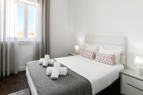 - une chambre avec un lit blanc et une fenêtre dans l'établissement Casa da Marginal, à Peniche