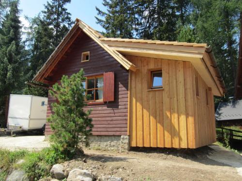 a tiny house in a yard with a garage at Zirbenwald Chalet in Turracher Hohe