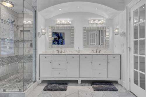 a white bathroom with two sinks and a shower at Buckheaddream Atlanta6bdrms Wbath In Every Room in Atlanta