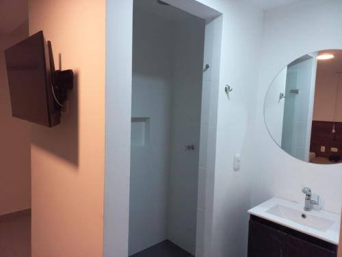 a bathroom with a sink and a mirror at Ayenda Colombia Avenida in Medellín