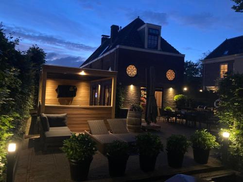 a house with a patio at night at Koetshuis aan het water 3 bedroom villa in Voorburg