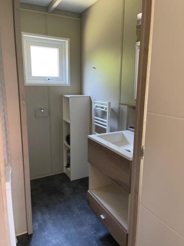 a small bathroom with a sink and a window at Chalet au calme dans la pinède in La Teste-de-Buch