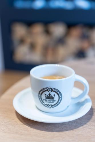 a cup of coffee on a plate on a table at President Apartman 7 in Vračar (historical)
