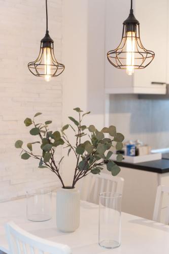 a table with two glasses and a vase with flowers at President Apartman 7 in Vračar (historical)