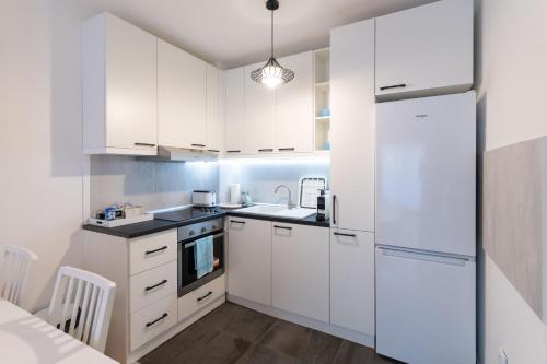 a kitchen with white cabinets and a white refrigerator at President Apartman 7 in Vračar (historical)